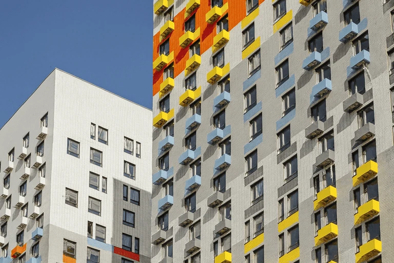 Фасад новостройки с окнами от застройщика